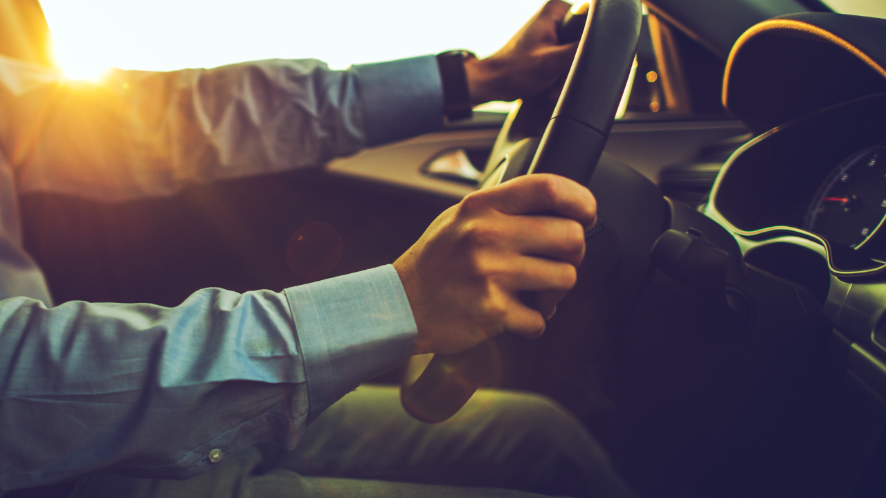 Conductor sujetando el volante de un coche que va a velocidad excesiva