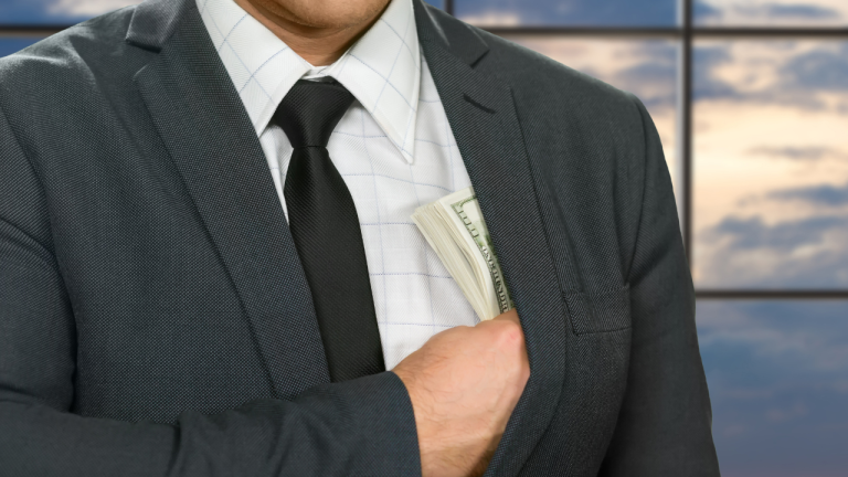 Hombre llevándose la mano al bolsillo interior de la chaqueta