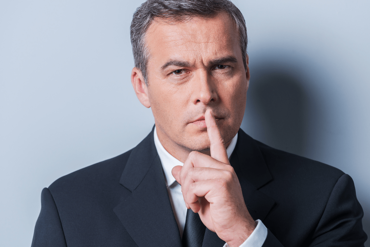 Administrador societario haciendo el signo de silencio