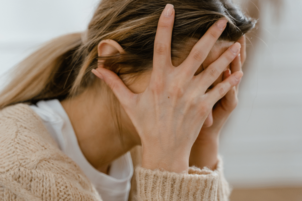 Mujer rubia con coleta tapándose la cara